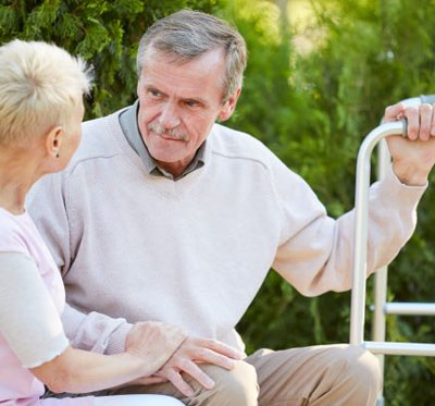 An elderly couple sitting together on a bench
