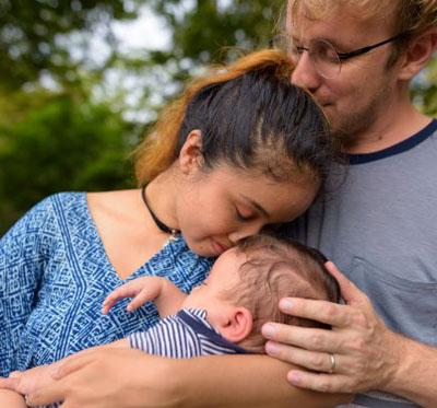 A couple holds their infant child