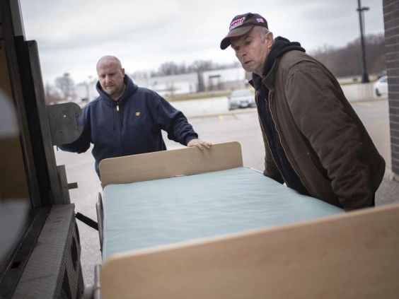 Pete Panzica, left, and David Purdie, from St. Clair College, load up hospital beds